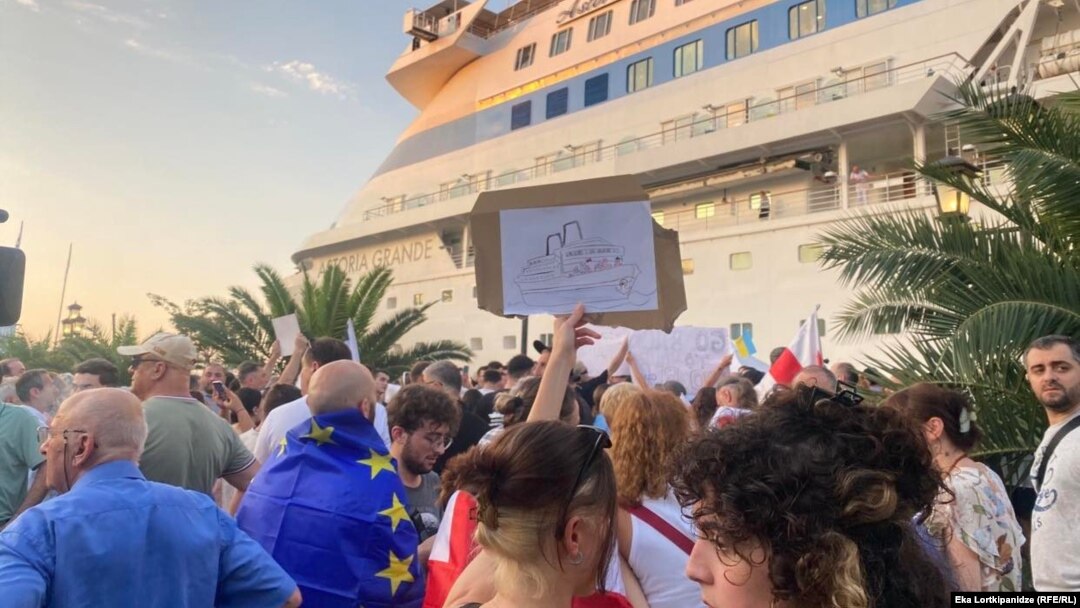 Demonstrators protest the presence of a cruise ship carrying Russian passengers in the Georgian port of Batumi on July 27