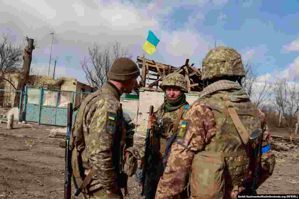 Українські військові розмовляють у нещодавно звільненому селі Лук&#39;янівка Київської області, березень 2022 року / На фото праворуч це ж місце у березні 2024 року