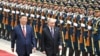 Russian President Vladimir Putin walks past a guard of honor with his Chinese counterpart, Xi Jinping, in Beijing last year. A new report says China has been bypassing EU sanctions in supplying Moscow with numerous goods used for military purposes. (file photo)