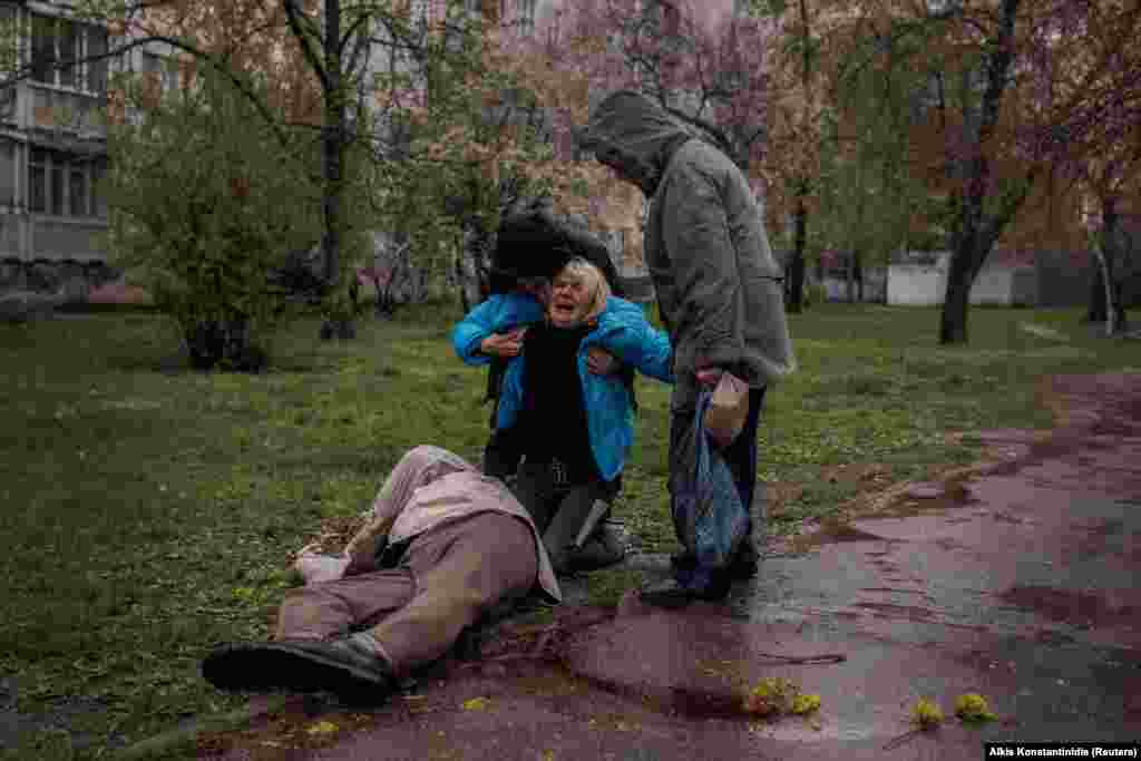 Яна Бачек, яку намагаються заспокоїти її партнер Євген Власенко і мати Любов, плаче над тілом свого батька Віктора Губарєва, який загинув, коли купував хліб під час обстрілу Харкова, Україна, 18 квітня 2022 року. World Press Photo Contest, Європа, одиночні фото: Яна та Віктор, Алкіс Константінідіс, Reuters