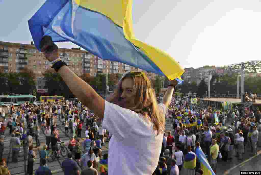 Серпень 2014 року. Український стяг майорить в руках учасниці проукраїнського мітингу в Маріуполі. Влада України контролювала Маріуполь майже 8 років. На початку повномасштабного вторгнення Росії Маріуполь опинився в оточенні армії РФ. Місто було майже повністю знищене внаслідок невпинних обстрілів російської армії. Під час облоги та тяжких боїв за Маріуполь там загинули десятки тисяч людей. Тільки серед цивільних, за даними міського голови Вадима Бойченка, кількість загиблих сягає 20 тисяч. Реальна цифра може бути більшою – точно встановити її наразі неможливо