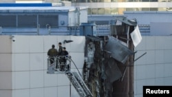Istražitelji rade u blizini oštećenog krova nakon što je prijavljeni ukrajinski dron oboren u Moskvi, Rusija, 18. avgusta 2023.