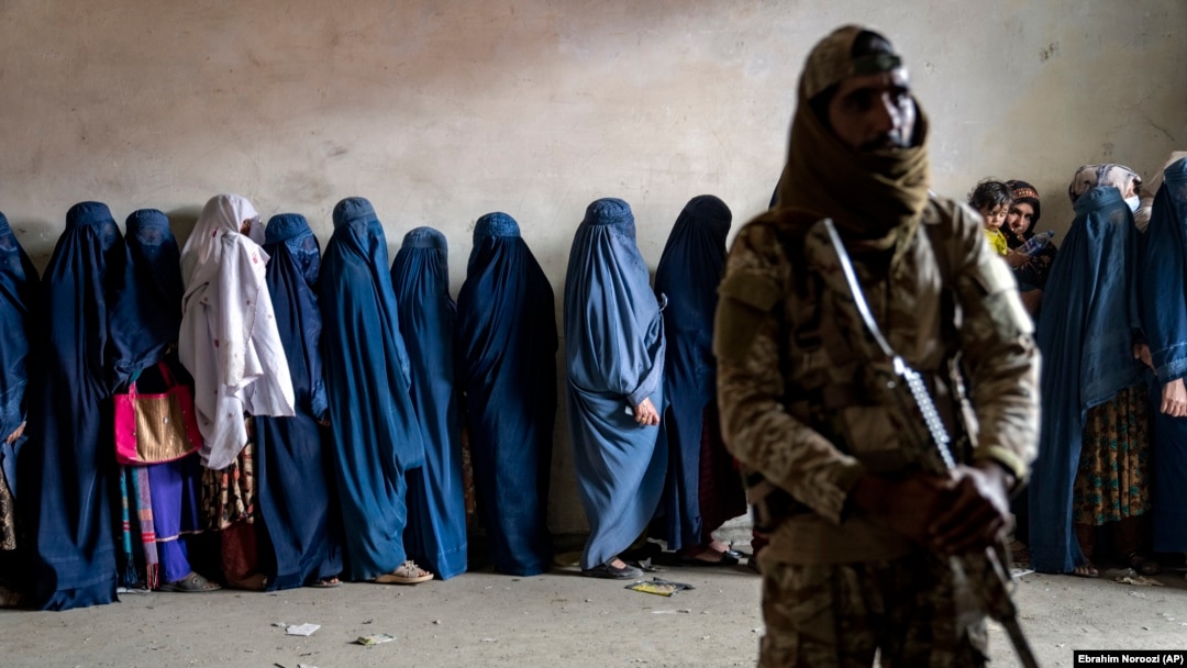 Talibanski borac stoji na straži dok žene čekaju da dobiju obroke hrane koje dijeli grupa humanitarne pomoći u Kabulu, 23. maj 2023. Od preuzimanja vlasti u augustu 2021., talibani su ponovo uspostavili jednu od najrigidnijih politika rodne diskriminacije u svijetu.