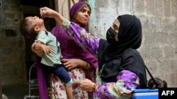 A health worker in Karachi administers polio drops to a child for vaccination on May 26, the first day of a nationwide week-long poliovirus eradication campaign.