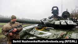 Український військовослужбовець біля пошкодженого російського танка Т-72БЗ під час масштабного вторгнення Росії до України. Ілюстративне фото