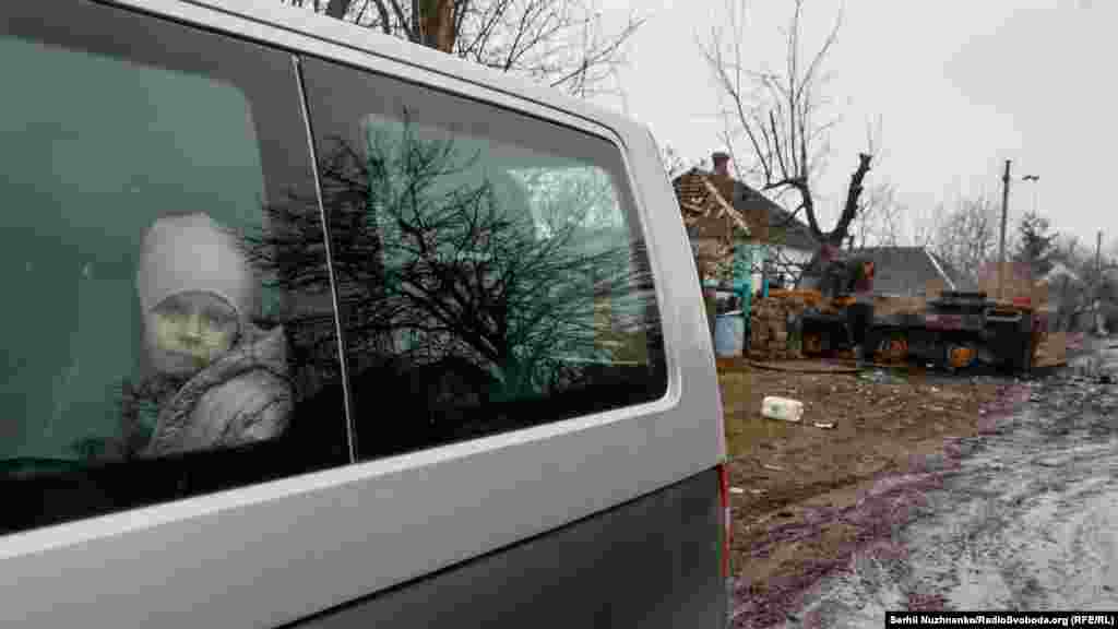 Ребенок в салоне машины, выезжающей из села на фоне подбитой российской бронетехники&nbsp;