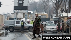 A Taliban security officer stands guard on a blocked road after a blast near Afghanistan's Foreign Ministry in Kabul on January 11. 