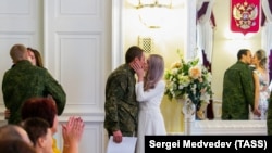 Молодожены во время церемонии бракосочетания в ЗАГСе