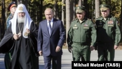 Глава РПЦ Кирило, президент Володимир Путін, міністр оборони Сергій Шойгу і начальник Генштабу Валерій Герасимов під час закладення каменю в фундамент головного храму армії Росії. Московська область, вересень 2018 року. Патріарх не приховує близькості до Кремля та Міноборони РФ