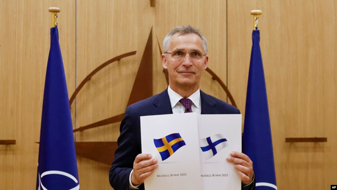 
Generalni sekretar NATO-a Jens Stoltenberg pokazuje dokumente da su Švedska i Finska podnele zahtev za članstvo, 18. maj 2022.

