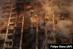 Firefighters tackle blazes in an apartment building after it was hit by shelling in Kyiv on March 15.