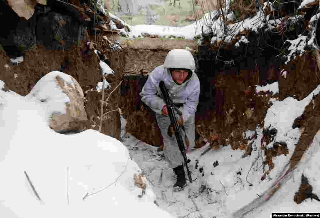 A fighter for the Kremlin-backed separatist group that calls itself the Donetsk People's Republic moves in a trench facing Ukrainian positions in the village of Zholobok in the Luhansk region.