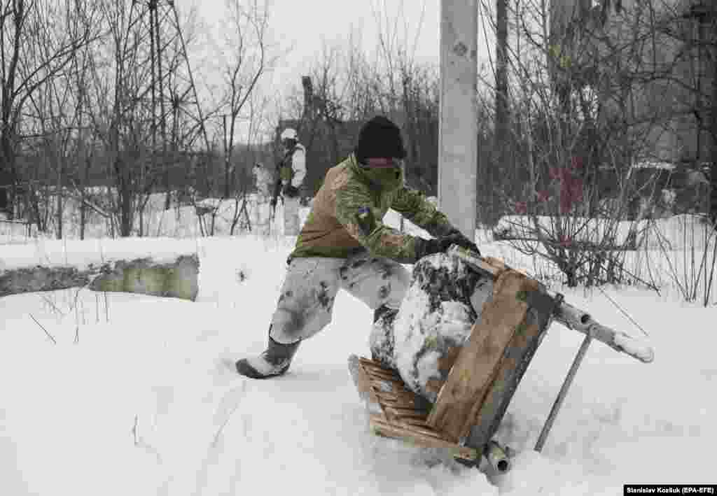 A Ukrainian soldier transports firewood at a frontline position near the village of Avdiyivka on January 25. 
