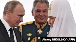 Президент Росії Володимир Путін, міністр оборони Сергій Шойгу і російський Патріарх Московський Кирило під час відвідування морського храму у День Військово-морського флоту в Санкт-Петербурзі. 30 липня 2017 року