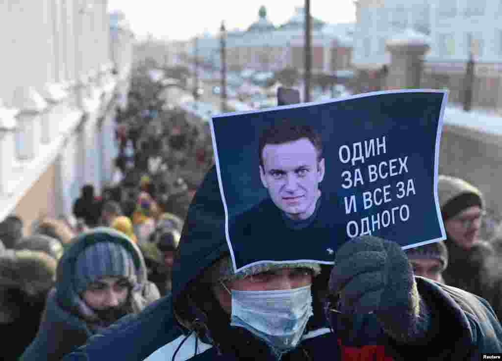 Un bărbat arată o pancartă pe care scrie "Toți pentru unul, unul pentru toți" în timpul unei manifestații din Omsk.