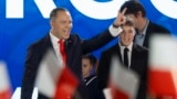 Karol Nawrocki, candidate for the 2025 Polish presidential election supported by Poland's right-wing Law and Justice (PiS) party, flashes the victory sign in front of supporters as exit polls were announced on tv during their election night event at the M