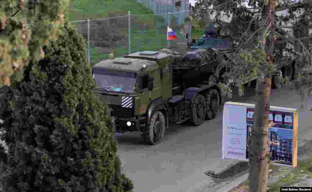 Un camion militar rusesc se apropie, pe 15 decembrie, de intrarea în baza aeriană Hmeimim, care se află la mică distanță de orașul Latakia, din vestul Siriei. Această fotografie este una din câteva făcute recent de Umit Bektas, un fotoreporter turc care lucrează pentru Reuters și care a relatat pentru Europa Liberă despre este situația din jurul bazei rusești.