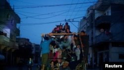 Refugiați palestinieni fug din Rafah după ce forțele israeliene au lansat o ofensivă terestră și aeriană în estul orașului.