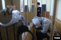 Karaulova covers her face from photographers in a Moscow courtroom on December 1.