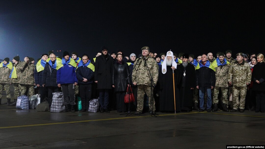 Президент України Петро Порошенко (посередині), праворуч від нього предстоятелі УПЦ КП Філарет, УПЦ (МП) Онуфрій та звільнені з полону українці. Харків, 27 грудня 2017 року
