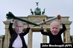 Громадські активісти в масках президента Росії Володимира Путіна (ліворуч) і президента США Джо Байдена позують з імітацією ядерних ракет перед Бранденбурзькими воротами в Берліні. 2021 рік