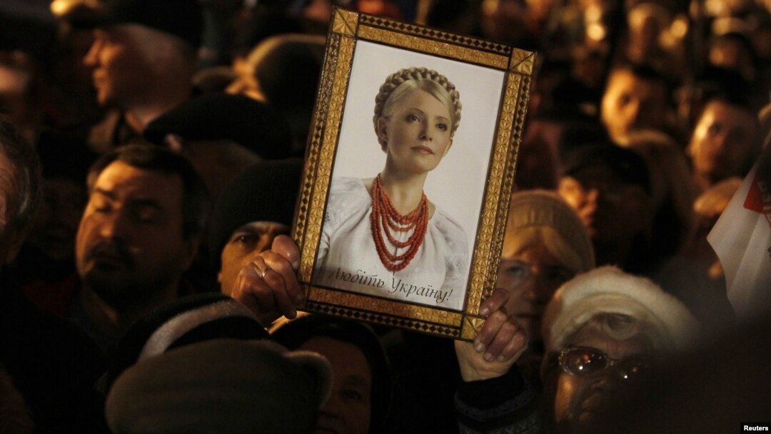 An opposition supporter at a protest rally in Kyiv on November 12 holds up a portrait of jailed opposition leader Yulia Tymoshenko.