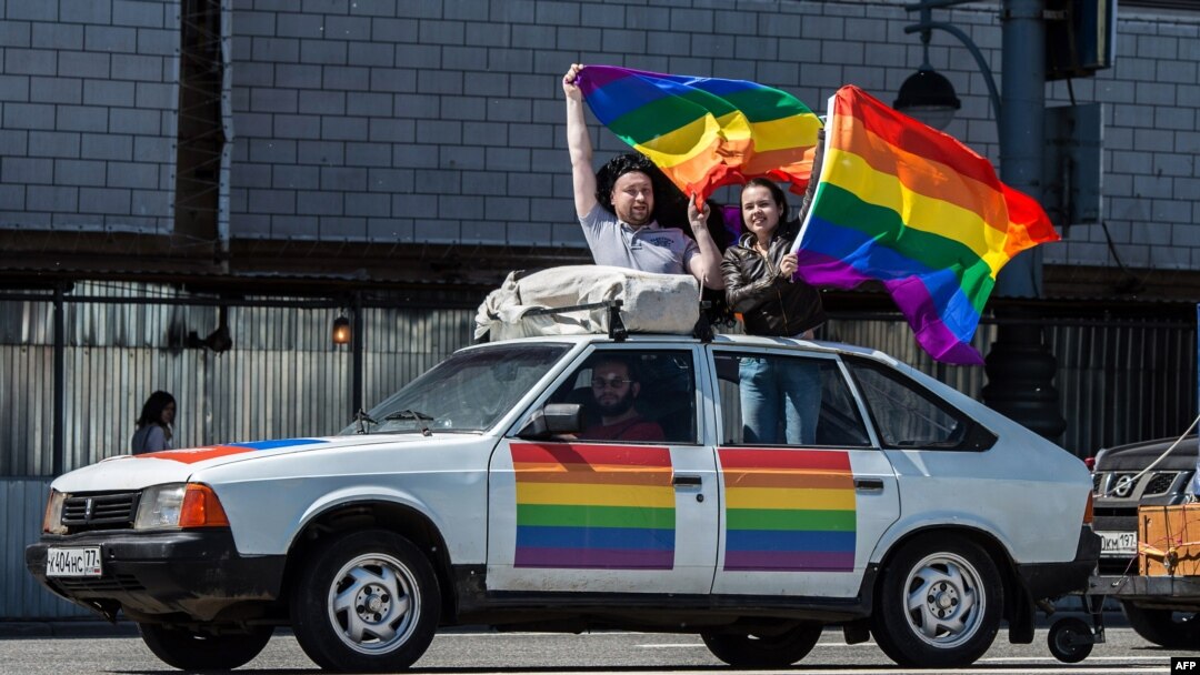 Gay-rights activists hold rainbow flags on top of a car during a protest in central Moscow on May 31.