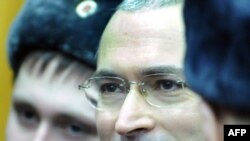 Bivši generalni direktor naftne kompanije Jukos Mihail Hodorkovski (lijevo) stoji pored svog bivšeg poslovnog partnera Platona Lebedeva (desno), iza staklenog zida u sudnici, u Moskvi, 27. decembar 2010.