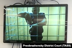 Росія. Москва. Російський опозиціонер Олексій Навальний (на екрані) під час засідання Преображенського суду за позовом до СІЗО -1 «Матроська Тиша» про визнання Навального схильним до втечі, щоб надати адвокату блогера можливість ознайомитися з матеріалами справи. 25 червня 2021 року