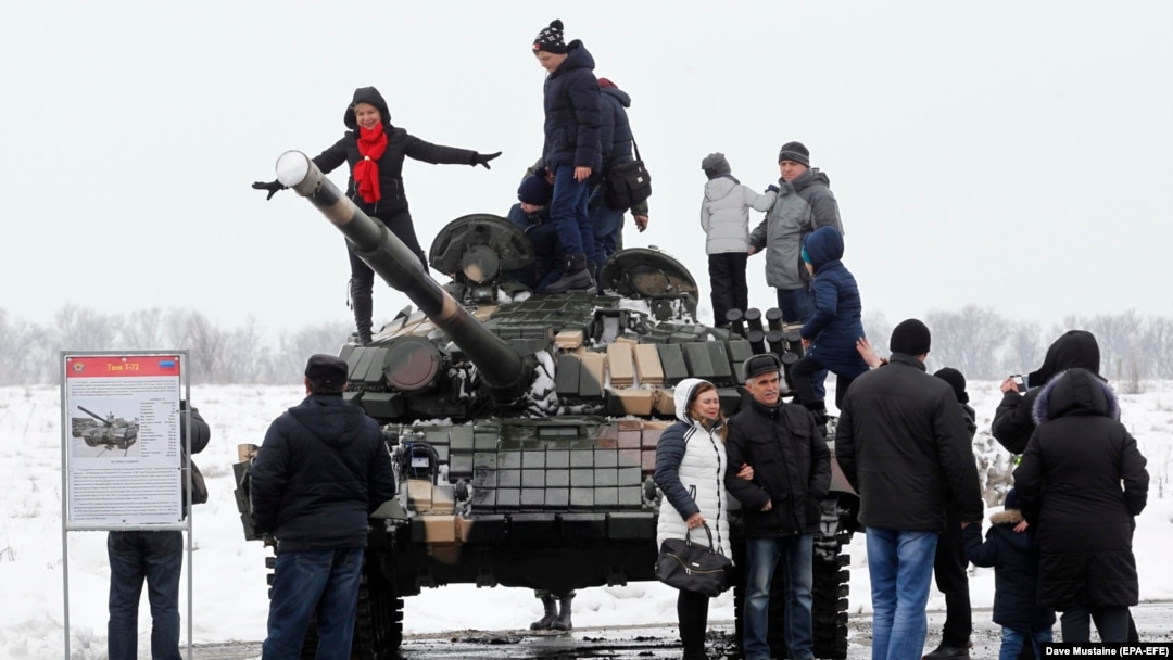 Mještani poziraju na tenku T-72 separatističkih snaga tokom proslave Dana branioca otadžbine na bivšem aerodromu u Lugansku u februaru 2020.