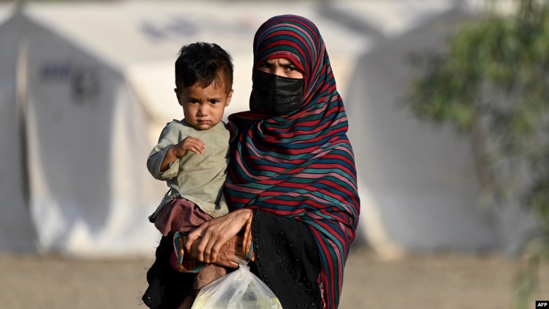 Afganistanka drži dijete dok stiže iz Pakistana u improvizirani kamp blizu afganistansko-pakistanske granice Torkham u provinciji Nangarhar 20. aprila