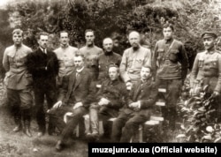 Всеволод Петрів (стоїть, третій справа). Керівники Директорії, уряду та армії УНР. Кам’янець-Подільський, липень 1919 року. Сидять (зліва направо): Ф. Швець, С. Петлюра, А. Макаренко. Стоять (зліва направо): ад'ютант Петлюри О. Доценко, начальник канцелярії М. Миронович, полковник Куликівський, сотник Осецький, генерал-квартирмейстер Генерального штабу О. Шайбле, військовий міністр УНР В.Петрів, посильний Г. Швець, начальник Головної юридичної управи Є. Мошинський (ЦДАКФДУ)