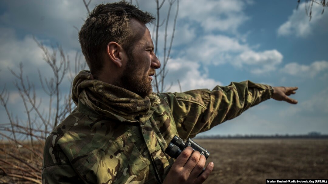 Український військовий показує в напрямку позицій підтримуваних Росією бойовиків