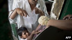 Dječak u Pakistanu uzima hranu iz javne kuhinje uzima hranu, arhiva, jul 2010