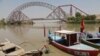 A man wades next to his boat along the Indus River near the Lansdowne Bridge in Sukkur, in Pakistan's southern Sindh Province on April 28. 