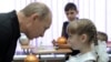 Vladimir Putin talks with a pupil during a visit to a schoo