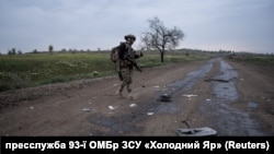 Военный 93-й ОМБР на дороге Торецко-Покровского направления. На земле – остатки российского дрона-камикадзе, май 2025 года