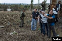 Співробітники ОБСЄ фотографують могилу в Нижній Кринці