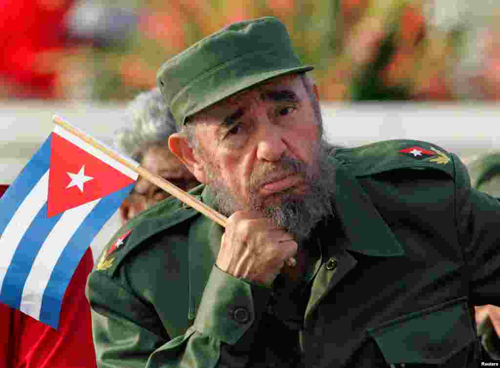 Holding a Cuban flag, Castro listens to a speaker during the May Day parade in Havana&#39;s Revolution Square in 2005.