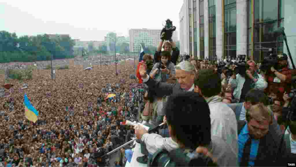 Виступ президента РРФСР Бориса Єльцина на мітингу в Москві, 20 серпня, 1991 року. На мітингу майорять і українські прапори, на передньому плані – синьо-жовтий прапор, а на задньому – червоно-чорний. Українці брали активну участь в масових акціях у Москві, які, в кінцевому результаті, призвели до розпаду радянської імперії. Зокрема, із 1989 року в Москві діяла організація з назвою «ОУН-РУХ»