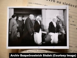 Fasciklu kojoj je Radio Slobodna Evropa imao pristupa sadrži fotografiju Majke Tereze (druga zdesna) koja je stigla na aerodrom u Pragu 1984. U bilješkama u njenom dosjeu se navodi da je tajna policija htjela dokumentirati ko je pozdravio slavnu katoličku sestru kada je ušla u zemlju.