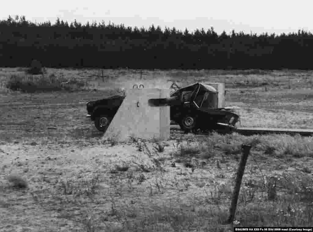 Автомобіль врізається у загородження на секретному випробувальному полігоні в Східній Німеччині. Тут випробували перешкоди, які мали завадити людям швидко пробиратися на волю через контрольно-пропускні пункти Східного Берліна. Ця фотографія з 1980 року – одна із кількох документів, що зберігаються в архіві «Штазі» Німеччини. Вони показують, яких заходів вживала влада Східної Німеччини, щоб гарантувати, що будь-хто, хто спробує втекти з комуністичної держави, буде зупинений або вбитий