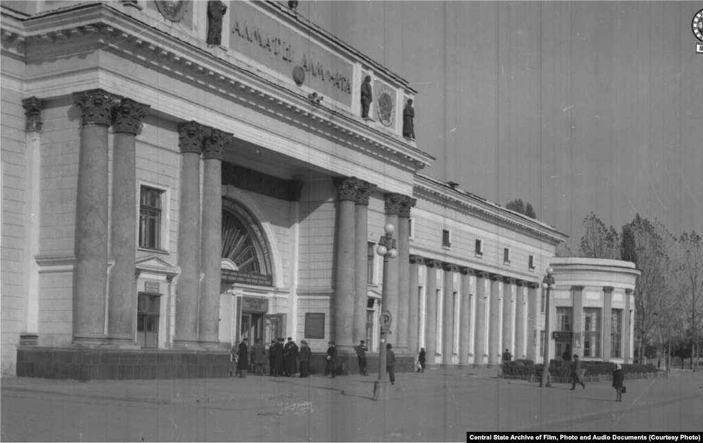 Здание железнодорожного вокзала в городе Алма-Ате. 1950 год (слева). В Верном — так назывался город до 1921 года — в этом районе располагалось кладбище. К моменту строительства вокзала погост был снесен селевым потоком. Здание строилось в 1936–1939 годах архитекторами Галкиным и Кудрявцевым. Пережило реконструкцию в 1977 году и капитальный ремонт в 2012-м. Выходящая к вокзалу улица четыре раза меняла свое наименование: названная Старокладбищенской во времена Верного, в 1933 году она превратилась в проспект Сталина, в 1961 году стала Коммунистическим проспектом, а сейчас называется Абылай-хана.