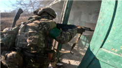 Розвідник 15-ої бригади НГУ «Кара-Даг» перевіряє будинок, де можуть бути російські солдати
