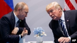 Фото від 7 липня 2017 року. Тогочасний президент США Дональд Трамп розмовляє із очільником Росії Володимиром Путіним на саміті G-20 у Гамбурзі. Німеччина. Тоді розмова тривала більше двох годин.