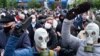 Протестувальники в протигазах та захисних масках від коронавірусу стоять в черзі, щоб поставити підписи за кандидатуру опозиційного кандидата на президентських виборах в Білорусі. Мінськ, 31 травня 2020 року