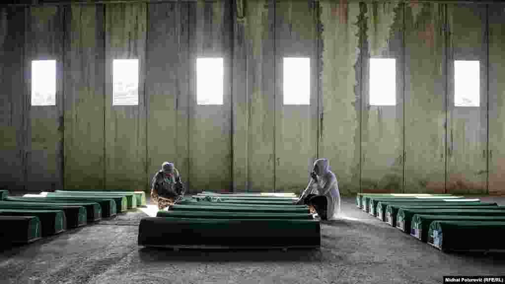 Tabuti sa ostacima 71 žrtve genocida u Srebrenici pred ukop u Memorijalnom centru Potočari. Svake godine porodice ukopavaju pronađene i identifikovane ostatke svojih namilijih, ubijenih u genocidu 1995. godine. General Vojske Republike Srpske Ratko Mladić osuđen je na doživotnu robiju u novembru pred sudom u Hagu, između ostalog, i zbog genocida u Srebrenici. (RFE/RL, Midhat Poturovic)