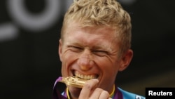 Kazahstanac Aleksandr Vinokurov grize zlatnu medalju za osvojeno porvo mjesto u biciklizmu na hronometar, 28, juli 2012.
