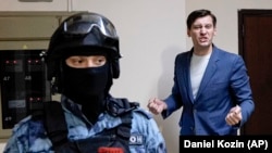 Russian opposition activist Dmitry Gudkov speaks to the media as police search his country home outside Moscow on June 1.