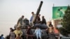 <p> Afghan men and children sit atop the remains of a Soviet-era tank on a square in Herat. 